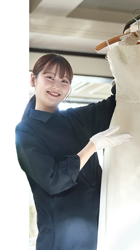 コーディネーターがウェディングドレスの前でご案内する様子