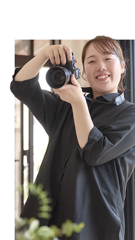 女性カメラマンがカメラを構える様子