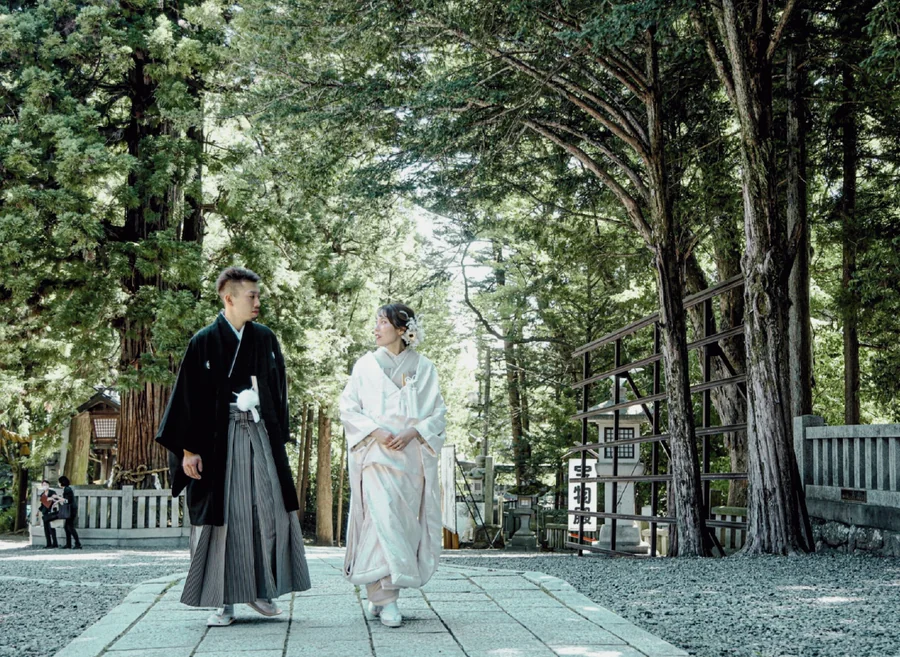 木漏れ日の参道を歩く新郎新婦